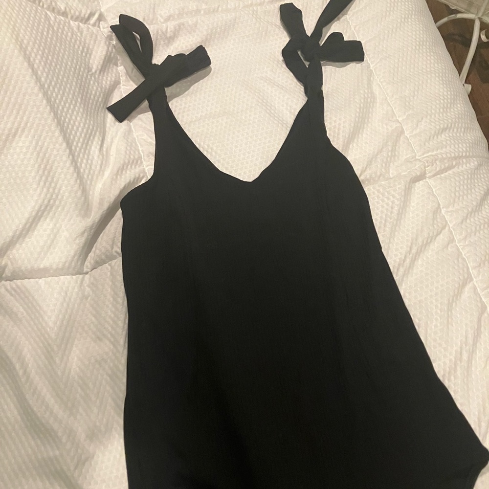 Thick ribbed black bodysuit ties at the shoulders.